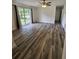 Spacious living room with a large window, ceiling fan, and wood-look flooring at 985 N Village Dr, Deltona, FL 32725
