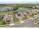 Aerial view showcases the homes, solar panels, and a scenic lake with lush green surroundings at 9873 Lost Creek Dr, Winter Garden, FL 34787