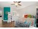 Comfortable bedroom with hardwood floors, white furniture, and bright turquoise accent wall at 9873 Lost Creek Dr, Winter Garden, FL 34787