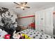 Cozy bedroom featuring hardwood floors, a ceiling fan, white wardrobe, and bed, plus exercise equipment and Mickey Mouse decor at 9873 Lost Creek Dr, Winter Garden, FL 34787