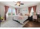 Cozy bedroom featuring a queen bed, rug, ceiling fan, and decorative curtains at 9873 Lost Creek Dr, Winter Garden, FL 34787