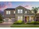 Stunning two-story home featuring a well-manicured lawn, a two-car garage, and solar panels for energy efficiency at 9873 Lost Creek Dr, Winter Garden, FL 34787