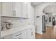 Close-up on the white cabinetry and countertop featuring stainless appliances and tiled backsplash at 9873 Lost Creek Dr, Winter Garden, FL 34787