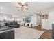 Bright living room with gray sofa, mounted TV, ceiling fan, and wood floors at 9873 Lost Creek Dr, Winter Garden, FL 34787