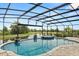 Stunning screened-in pool area with a spa, lush landscaping, and serene golf course views in the background at 9873 Lost Creek Dr, Winter Garden, FL 34787