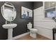 Stylish powder room with a pedestal sink, oval mirror, and modern fixtures for a sleek design at 9873 Lost Creek Dr, Winter Garden, FL 34787