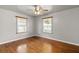 This bedroom features hardwood floors, a ceiling fan, and two windows with blinds at 1003 S Center St, Eustis, FL 32726