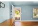 Inviting living room with hardwood floors, light blue walls, and an open door to the front yard at 1003 S Center St, Eustis, FL 32726