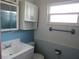 Bathroom featuring a vanity, toilet, and medicine cabinet, with bright blue tiling at 10208 Brownwood Ave, Orlando, FL 32825