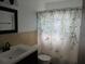 Bathroom featuring decorative shower curtain, classic tile, and stylish vanity with contemporary fixtures at 10208 Brownwood Ave, Orlando, FL 32825