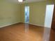 Cozy bedroom showcasing light colored walls, hardwood floors, and open bathroom door at 10208 Brownwood Ave, Orlando, FL 32825