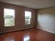 Living room featuring hardwood floors and well lit with two windows overlooking greenery outside at 10208 Brownwood Ave, Orlando, FL 32825