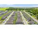 A high-angle showcases a community with rows of identical homes and manicured lawns, set amidst verdant landscapes and distant water features at 1120 Mattie Pointe Blvd, Auburndale, FL 33823