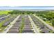 High-angle view of an expansive neighborhood features uniform homes and green landscapes, bordered by mature trees and clear blue skies at 1120 Mattie Pointe Blvd, Auburndale, FL 33823