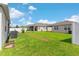 Spacious backyard featuring lush grass, privacy fence, and neighboring houses under a sunny sky at 1120 Mattie Pointe Blvd, Auburndale, FL 33823