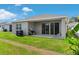 Backyard featuring lush grass, covered patio, AC unit, and sliding glass doors for indoor-outdoor living at 1120 Mattie Pointe Blvd, Auburndale, FL 33823