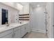 Modern bathroom with double sink vanity, glass-enclosed shower, and rustic floating shelves at 1120 Mattie Pointe Blvd, Auburndale, FL 33823
