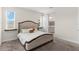 Bedroom featuring a large bed, two windows, and a bathroom, showcasing comfortable living at 1120 Mattie Pointe Blvd, Auburndale, FL 33823