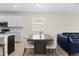 Bright dining room features a table for eight, a window, and an adjacent living room with comfortable, modern furniture at 1120 Mattie Pointe Blvd, Auburndale, FL 33823
