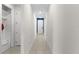 Long hallway features neutral tile flooring, white walls, and multiple doorways leading to different rooms in the house at 1120 Mattie Pointe Blvd, Auburndale, FL 33823