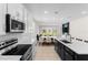 Modern kitchen with stainless steel appliances, granite countertops, and a center island connecting to the dining and living area at 1120 Mattie Pointe Blvd, Auburndale, FL 33823