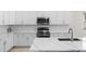 A contemporary kitchen features white cabinets, stainless steel appliances, quartz countertops, and a kitchen island at 1120 Mattie Pointe Blvd, Auburndale, FL 33823