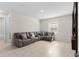Relaxing living room features a comfortable gray sectional sofa and a bright window, perfect for casual living at 1120 Mattie Pointe Blvd, Auburndale, FL 33823
