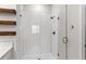 Shower with white tiles and glass door, and rustic shelves that adds a touch of style to the space at 1120 Mattie Pointe Blvd, Auburndale, FL 33823