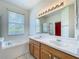 Bright bathroom with a double sink vanity, soaking tub, and a large mirror at 1131 Turtle Lake Ct, Ocoee, FL 34761