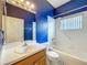 Bright bathroom featuring blue walls, a single vanity, and a shower-tub combo with white tile and updated fixtures at 1131 Turtle Lake Ct, Ocoee, FL 34761
