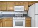 Well-lit kitchen featuring white appliances, granite countertops, and wood cabinets at 1131 Turtle Lake Ct, Ocoee, FL 34761