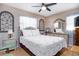 Comfortable bedroom featuring a ceiling fan and a decorative bedspread with a red floral design at 1135 Plato Ave, Orlando, FL 32809