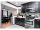 An open concept kitchen features dark cabinets, stainless appliances, and an eat in dining area at 1135 Plato Ave, Orlando, FL 32809