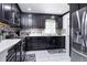 Modern kitchen with sleek black cabinets, stainless steel appliances, and stylish backsplash tiles at 1135 Plato Ave, Orlando, FL 32809
