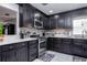 This is a kitchen with stainless steel appliances, dark cabinetry, and white countertops at 1135 Plato Ave, Orlando, FL 32809