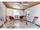 Inviting sun room with a wood plank ceiling, tile floor, and several rocking chairs with plush red cushions at 1135 Plato Ave, Orlando, FL 32809