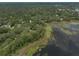 Panoramic aerial view of residences situated near a lake enveloped by lush trees at 120 E Greentree Ln, Lake Mary, FL 32746