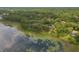 Expansive aerial view of a lush, wooded community alongside a serene lake with lily pads at 120 E Greentree Ln, Lake Mary, FL 32746