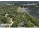 Aerial perspective reveals houses amid lush foliage along the edge of a calm lake at 120 E Greentree Ln, Lake Mary, FL 32746