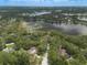 Wide aerial shot of residences neighboring a tranquil lake surrounded by dense tree coverage at 120 E Greentree Ln, Lake Mary, FL 32746