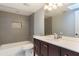 Bathroom featuring a shower-tub combo with gray tile, dark wood cabinets and white marble countertops at 120 E Greentree Ln, Lake Mary, FL 32746