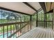 Enclosed deck featuring a wooded view and a partial view of the pool below at 120 E Greentree Ln, Lake Mary, FL 32746