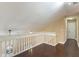 Upstairs hallway with dark hardwood floors, a white banister, and a view down the staircase at 120 E Greentree Ln, Lake Mary, FL 32746