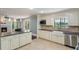Bright kitchen with white cabinetry, stainless steel appliances, and a view of the pool and lake at 120 E Greentree Ln, Lake Mary, FL 32746
