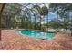 Screened-in pool area featuring a brick deck with lake view, inviting relaxation and outdoor enjoyment at 120 E Greentree Ln, Lake Mary, FL 32746