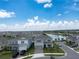 A high-angle view of houses with neatly kept lawns and a winding lake in the community at 13822 Destin Beach Ln, Orlando, FL 32827