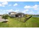 Spacious backyard features a screened-in pool and a tranquil lake view beyond the black fence at 13822 Destin Beach Ln, Orlando, FL 32827