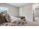 Light-filled bedroom with neutral paint, plush carpet, and doorway to another room at 13822 Destin Beach Ln, Orlando, FL 32827