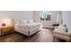 Bright bedroom with hardwood floors, a large window, bench and a stylish modern design at 13822 Destin Beach Ln, Orlando, FL 32827