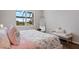 Serene bedroom featuring a window view, bench seating, and a soft, inviting floral patterned quilt at 13822 Destin Beach Ln, Orlando, FL 32827